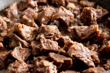 Yakın plan güzel büyük et parçaları ve tavada soğan.