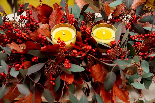 Zwei Orangefarbene Kerzen Umgeben Von Viburnum Beeren Und Bunten Grünen — Stockfoto
