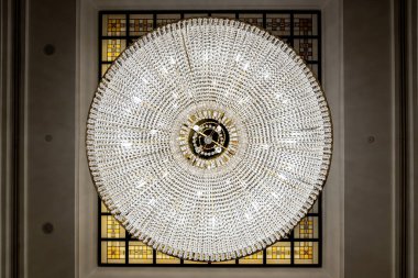 Tavanında kristaller ve şamdanlar olan büyük yuvarlak avize, koyu arka plan, eski tarz. Lüks odada güzel bir avize parlıyor..