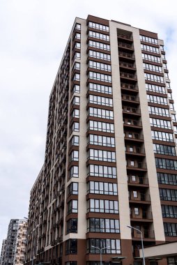 Gökyüzüne karşı çok katlı, yeni, kahverengi bir bina.