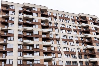 Gökyüzüne karşı çok katlı, yeni, kahverengi bir bina.