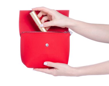 Kadın eli makyaj fırçasını kırmızı çantaya koy. Beyaz arka plan izolasyonunda güzellik makyaj malzemesi.