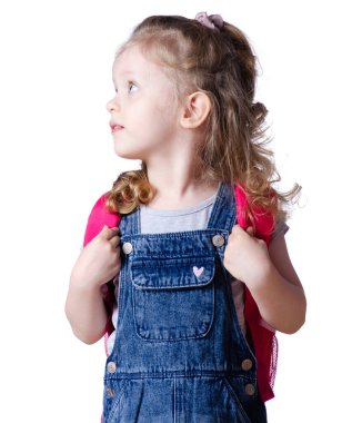 Sırt çantalı kız çocuğu beyaz arka plan izolasyonuna bakıyor. Çocukluk, eğitim, ürünler çocuklar