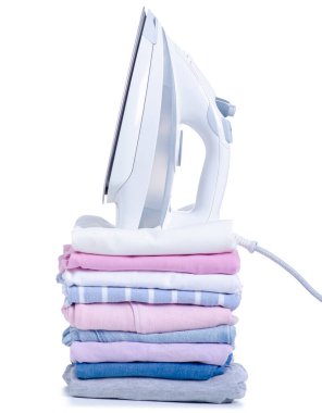 Beyaz arka plan izolasyonuna renkli giysiler ve elektrikli ütü yığını