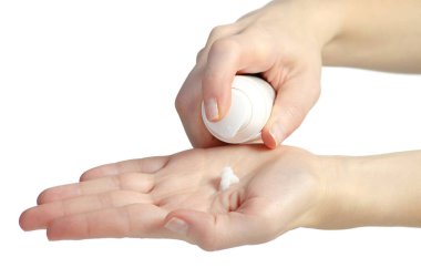 Kadın beyaz arka plan izolasyonuna el kremi döküyor. Kadın eli kozmetik ürünleri tutuyor, yakın plan..