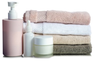 Katlanmış havluları plastik şişe, spa, banyo ürünleri ile birlikte beyaz arka plan izolasyonuna koyun.