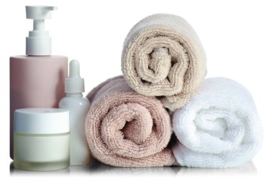 Katlanmış havluları plastik şişe, spa, banyo ürünleri ile birlikte beyaz arka plan izolasyonuna koyun.