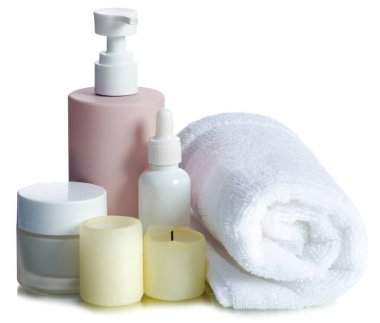 Katlanmış havluları plastik şişe, spa, banyo ürünleri ile birlikte beyaz arka plan izolasyonuna koyun.