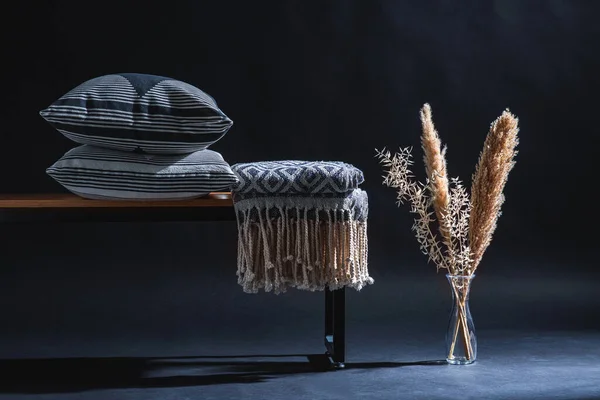 室内装饰和家居装饰概念 长椅上的枕头和毛毯 深色房间地板上的花瓶里的干植物 — 图库照片