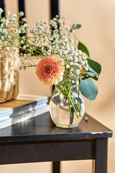 家居装饰与设计理念 将玻璃瓶中的花朵密闭在米色背景的老式椅子上 — 图库照片