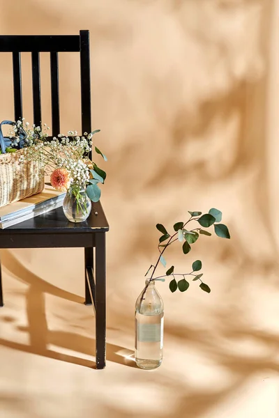 家居装饰和设计理念 在米色背景的老式椅子上 用篮子 玻璃瓶和杂志把花包起来 — 图库照片