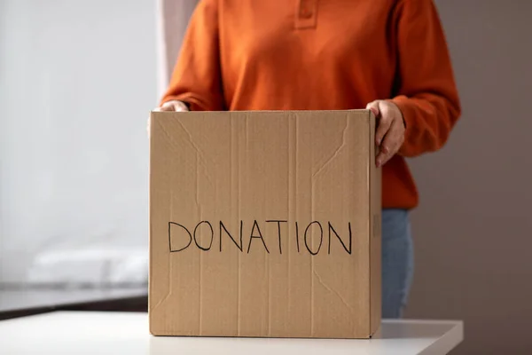 チャリティーとボランティアのコンセプト 家庭で寄付をして段ボール箱を持っている若い女性 — ストック写真