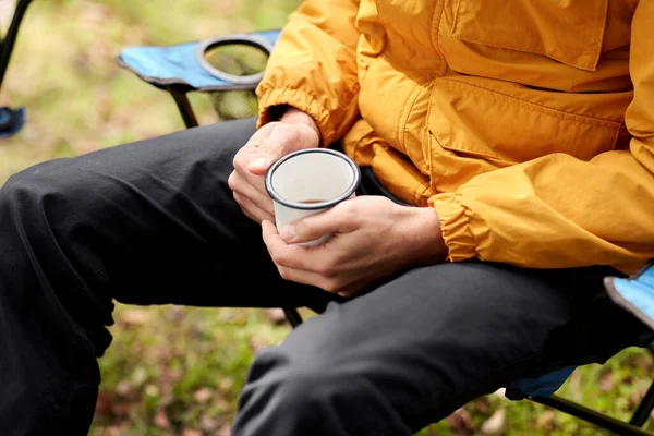 キャンプ 旅行のコンセプト キャンプでマグカップを飲みながらお茶を飲む男の終わり — ストック写真