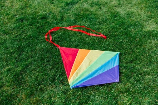 子供時代とレジャーゲームのコンセプト 緑の芝生や草の上で多色の凧のクローズアップ — ストック写真