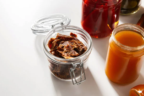 food, eating and storage concept - jar with beef jerky or pastrami and preserves on white table