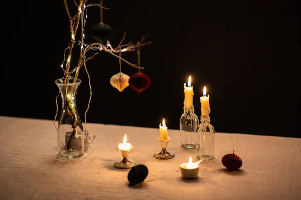 冬の休日 家の装飾およびお祝いの概念 黒い背景の上のテーブルで燃えるクリスマスの装飾およびろうそく — ストック写真