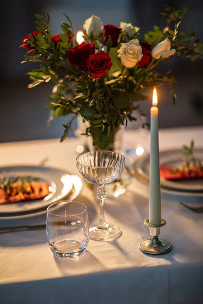 ディナーパーティー お祝いのコンセプト 花瓶とバレンタインデーに自宅で燃えているろうそくの花と2のために役立つお祝いのテーブルの閉鎖 — ストック写真
