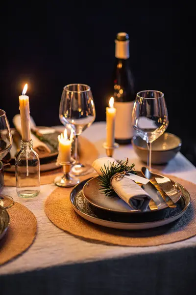 winter holidays, dinner party and celebration concept - close up of scandinavian christmas table serving with burning candles at home at night