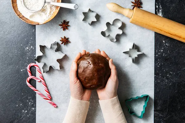 烹调和圣诞节概念 双手合拢 将姜饼面团和配料放在厨房黑桌顶部 — 图库照片