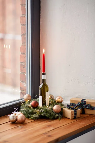 冬休み クリスマス お祝いのコンセプト 家の窓のワインボトルに燃える赤いろうそくで火の輪の閉鎖 — ストック写真