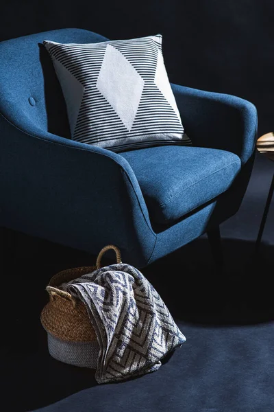 室内装潢和家居装潢概念 用黑色墙壁上方的篮子里的枕头和毛毯把蓝色椅子关上 — 图库照片