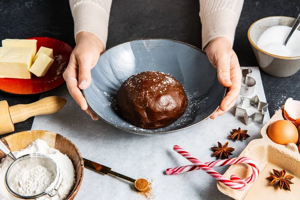 烹调和圣诞节概念 双手合拢 将姜饼面团和配料放在厨房黑桌顶部 — 图库照片