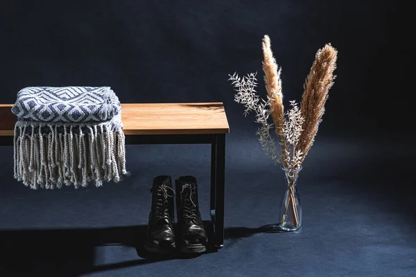 インテリアと家庭の装飾コンセプト ベンチ レースアップブーツ ダークルームの花瓶の乾燥した植物の毛布 — ストック写真