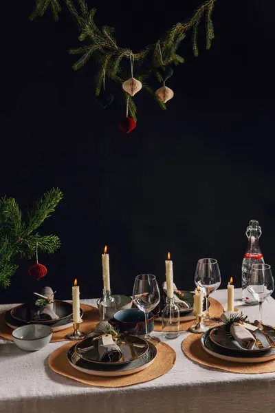 winter holidays, dinner party and celebration concept - scandinavian christmas table serving with burning candles at home over black background