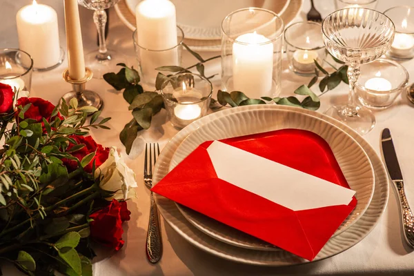 ディナーパーティー お祝いのコンセプト 赤いバラを提供するお祝いのテーブルの閉鎖 バレンタインデーの夜に家で愛のメッセージと燃えるろうそく — ストック写真