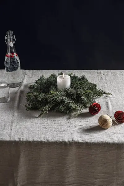 冬休みやお祝いのコンセプト 燃えるろうそく クリスマスのおもちゃ 黒い背景の上のテーブル上の水のガラス瓶で火の輪の閉鎖 — ストック写真