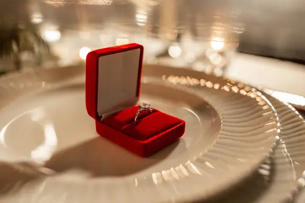 情人节及求婚概念 在家中餐桌上用红盒子把订婚戒指合上 — 图库照片