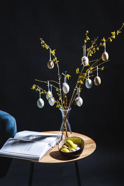 インテリア ホームデコレーションコンセプト ダークルームのテーブルの上にVisythia枝と雑誌と花瓶のイースターエッグのクローズアップ — ストック写真