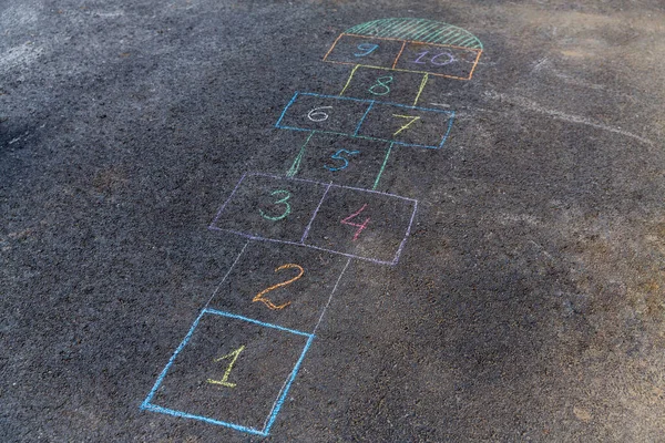 leisure games and childhood concept - close up of hopscotch chalk drawing on asphalt pavement
