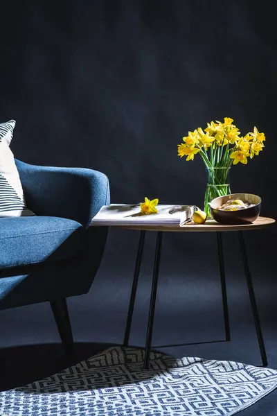 室内装饰 假日和家居装饰概念 现代蓝色椅子 有枕头 挂在碗里的牡蛎蛋 深色房间桌上的水仙花 — 图库照片