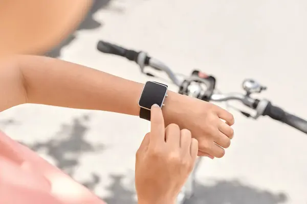 休闲和体育 在城市街道上骑智能手表自行车的妇女的近身生活 图库图片