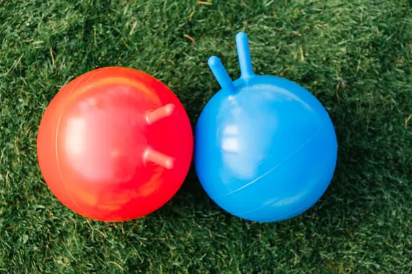 子供時代 レジャー おもちゃのコンセプト 芝生の上で2つのバウンスボールやホッパー ストックフォト