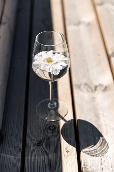 オブジェクト 夏と飲み物のコンセプト 木製のベンチに花と水のガラスの閉鎖 ロイヤリティフリーのストック写真
