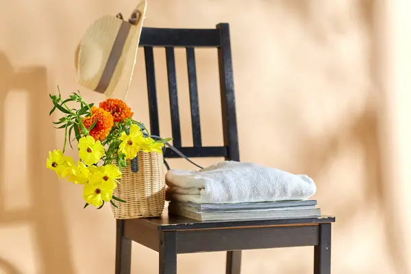 家居装饰和设计理念 用篮子 帽子和杂志装饰在米色背景的老式椅子上 图库照片