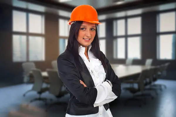 一个戴着头盔的年轻工程师象征着专业精神和创新精神 代表着对充满活力的建筑领域的安全和信心 图库图片