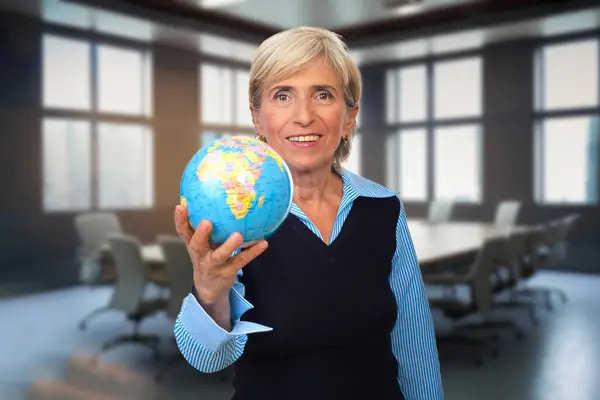 Eine Ältere Frau Hält Den Globus Einem Konferenzraum Und Symbolisiert Stockfoto