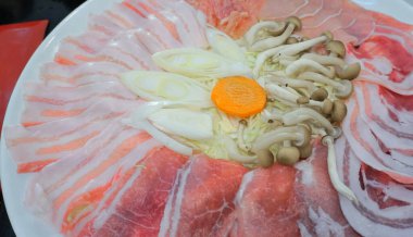 Çiğ domuz eti ve mantar sıcak tencerede kaynatmak için.