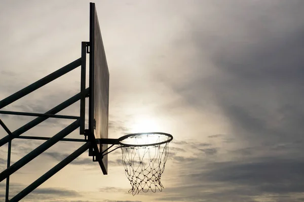 日没の空を背景にしたバスケットボールのフープ — ストック写真