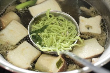 Mantarlı sıcak tencerede haşlanmış erişte.