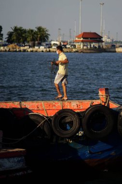 CHONBURI, THAILAND - 10 DEC : Man pull rope at boat on 10 December 2022 in Siracha, Chonburi, Thailand
