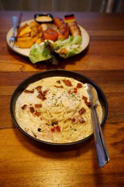 Tahta masada Alman sosisli spagetti carbonara.