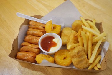 Soslu, patates kızartmalı ve sosisli.