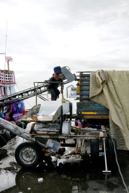 CHONBURI, THAILAND - 11 SEP: İşçiler 11 Eylül 2023 tarihinde Si racha, Chonburi, Tayland 'da bir balıkçı teknesine taşınmadan önce buz küplerini öğütücüye taşıdılar