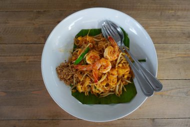 Karidesli Pad Thai, ahşap masada Tayland mutfağı.