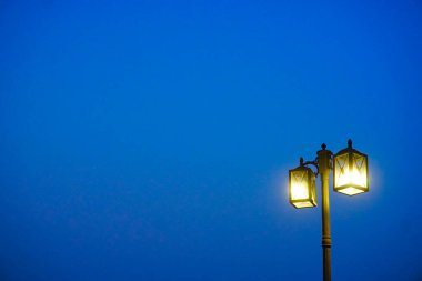 Alacakaranlık arkaplanına sahip lamba direğinde ışık