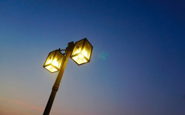 Alacakaranlık gökyüzü arkaplanı, düşük açı görünümlü lamba direğinde ışık